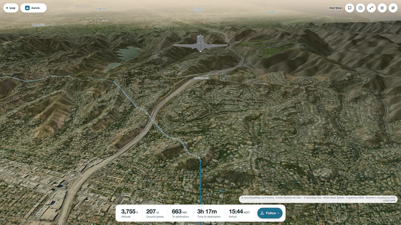 The follow view just after take-off from Van Nuys: the jet climbing toward the Sepulveda Pass, with hillside streets, the freeway through the pass and a reservoir in the Santa Monica Mountains sharp below