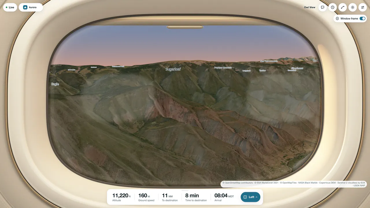 The left window view descending into Aspen at golden hour: forested ridges and red rock above the Roaring Fork valley under a pink sky, framed by an ivory cabin window with its shade raised